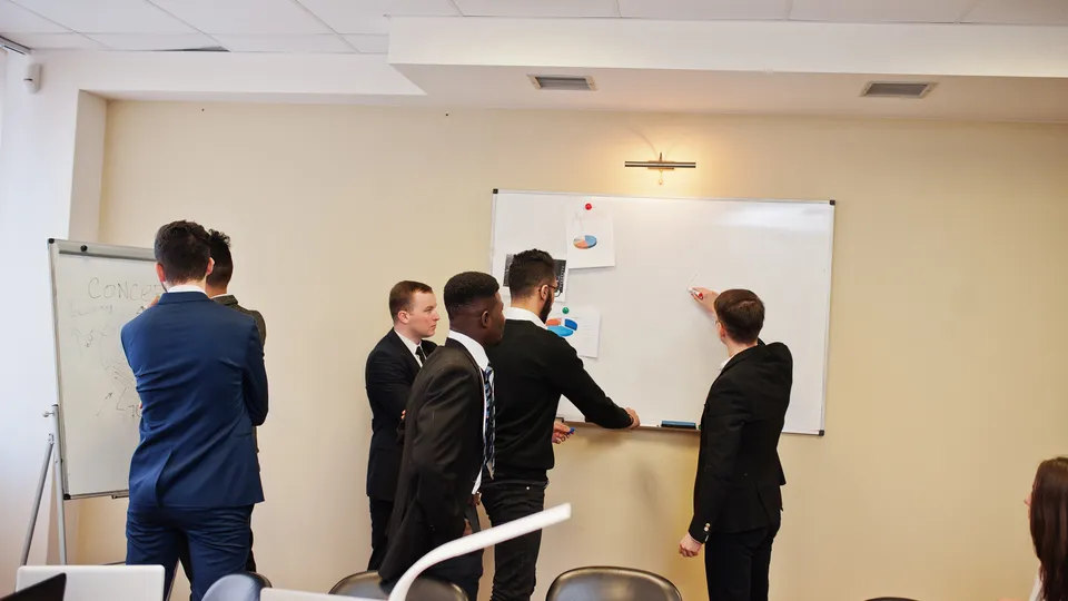 Illustrative photo: Professionals collaborating on plans around a table.