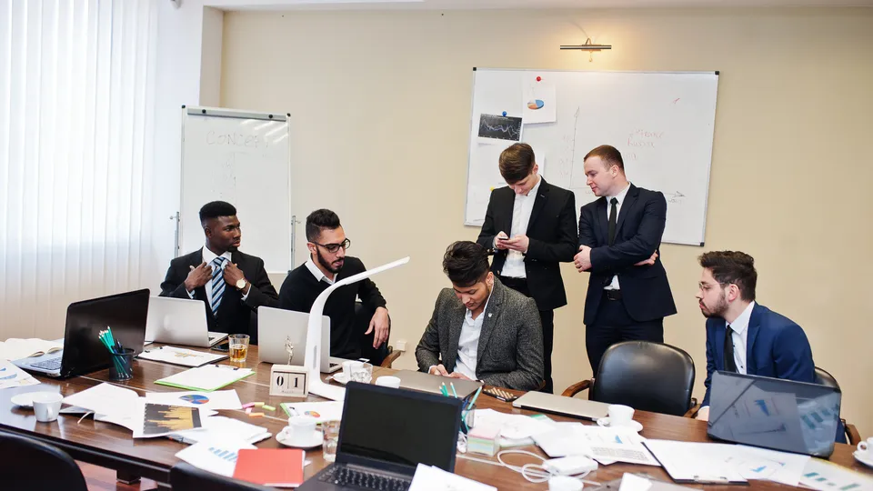 Illustrative photo: Professionals meeting around a conference table.