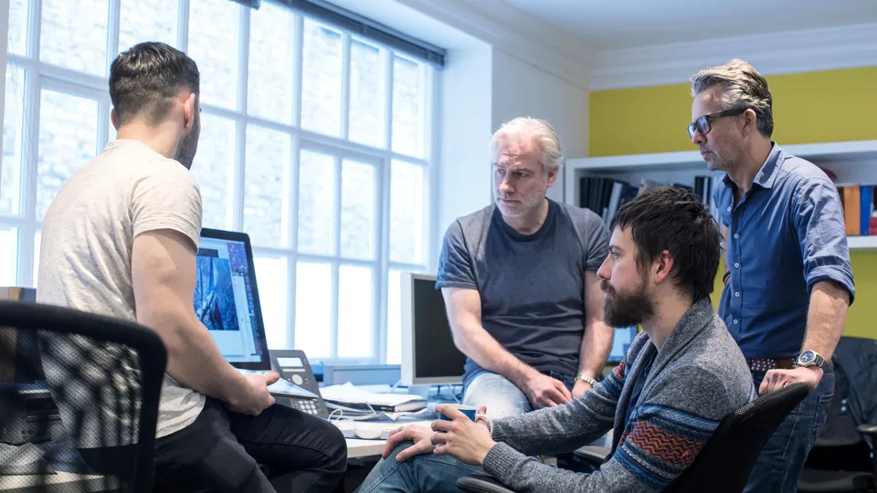 Illustrative photo: Team collaborating around an office table.