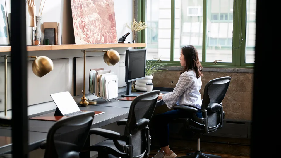Illustrative photo: Woman working at a desk in a quiet office.