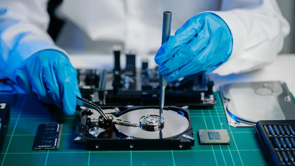 Illustrative photo: Technician working on an open hard disk in a laboratory.