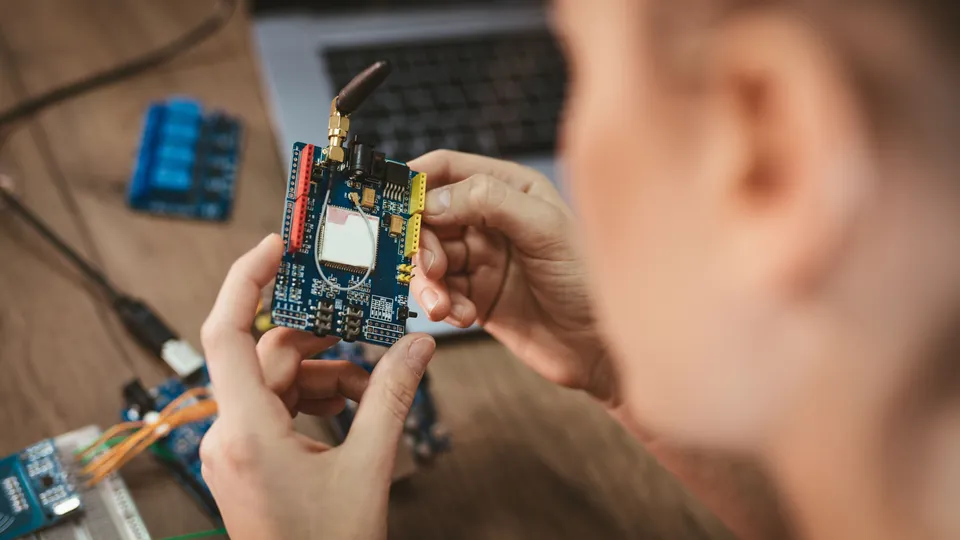 Illustrative photo: Engineer inspecting an electronic development board.