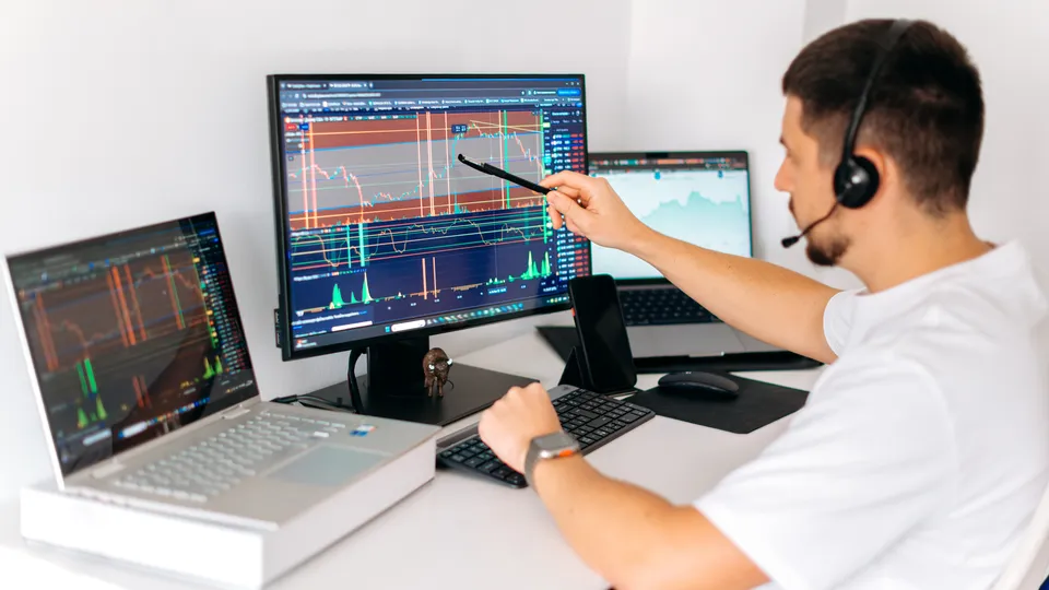 Illustrative photo: Analyst reviewing charts on a computer.