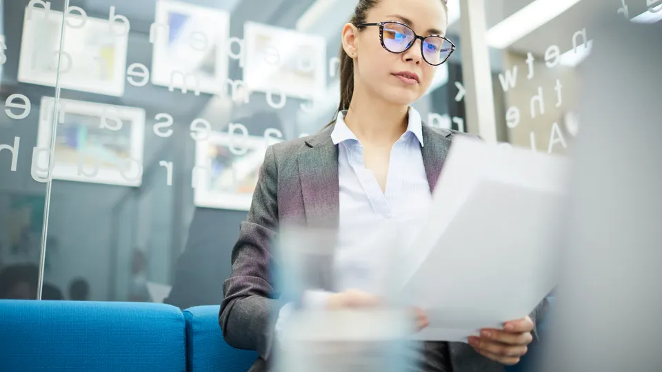 Illustrative photo: Woman reviewing a document in an office.