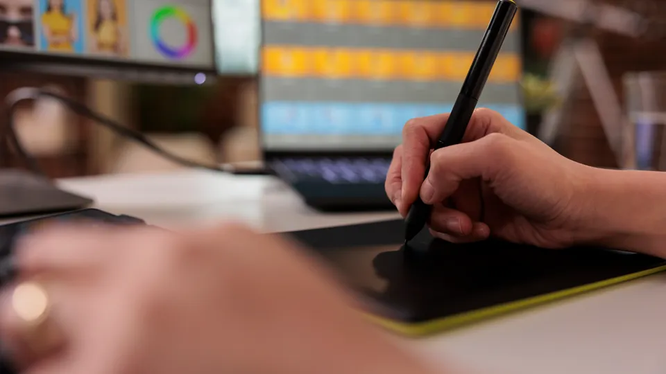 Illustrative photo: Designer using a graphics tablet in front of a monitor.