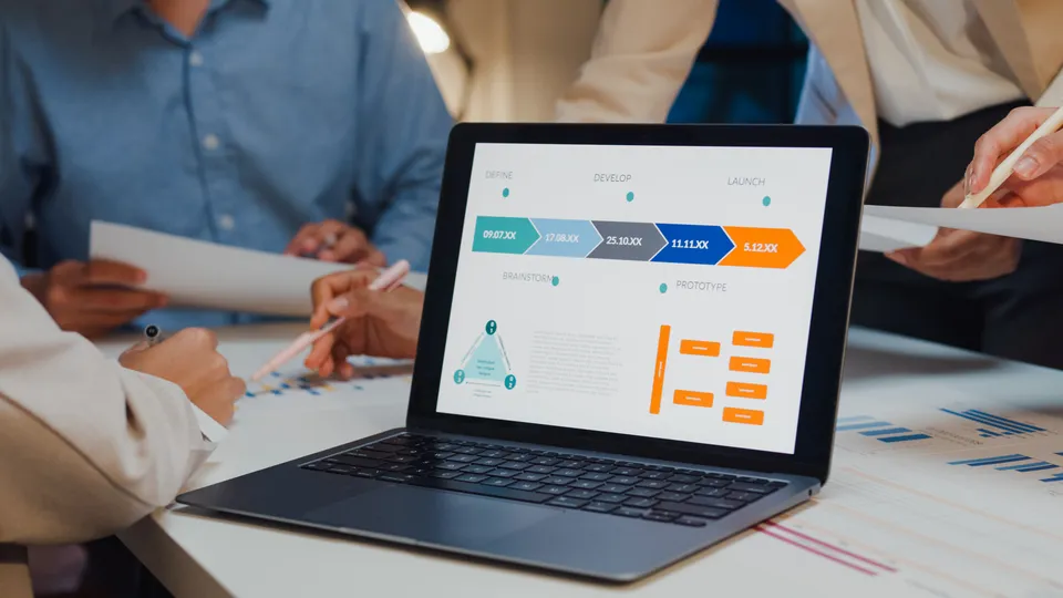 Illustrative photo: Laptop displaying a process diagram during a team meeting.