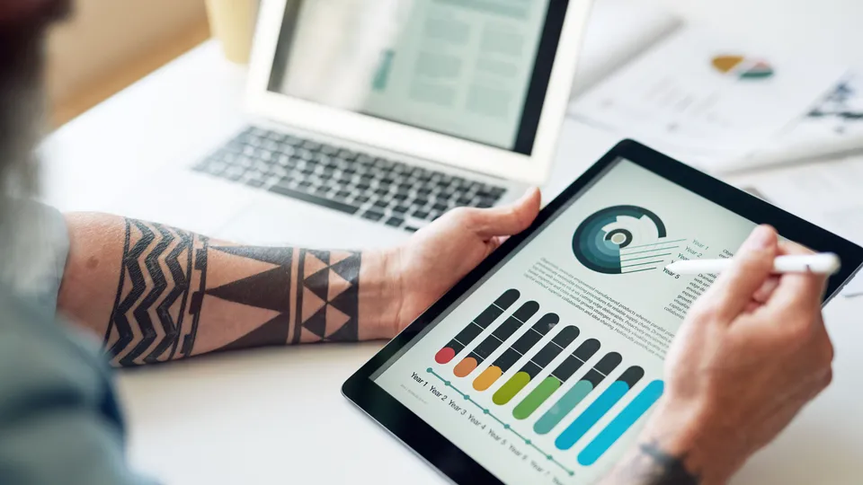 Illustrative photo: Hands reviewing a performance dashboard on a tablet.