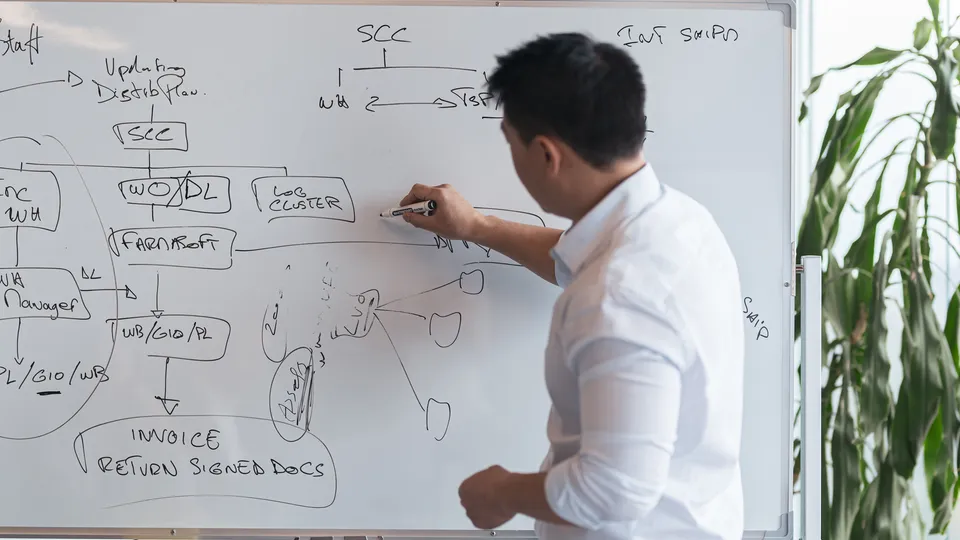 Illustrative photo: Man drawing a connected diagram on a whiteboard.