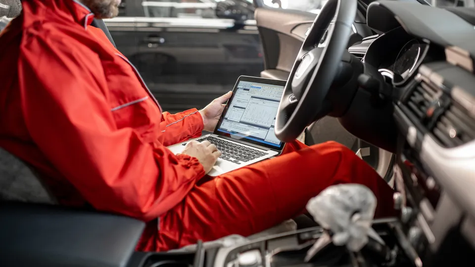 Illustrative photo: Mechanic using a diagnostic laptop inside a car.
