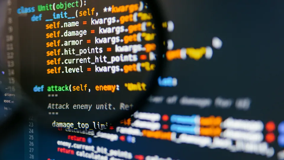 Illustrative photo: Magnifying glass enlarging source code on a screen.