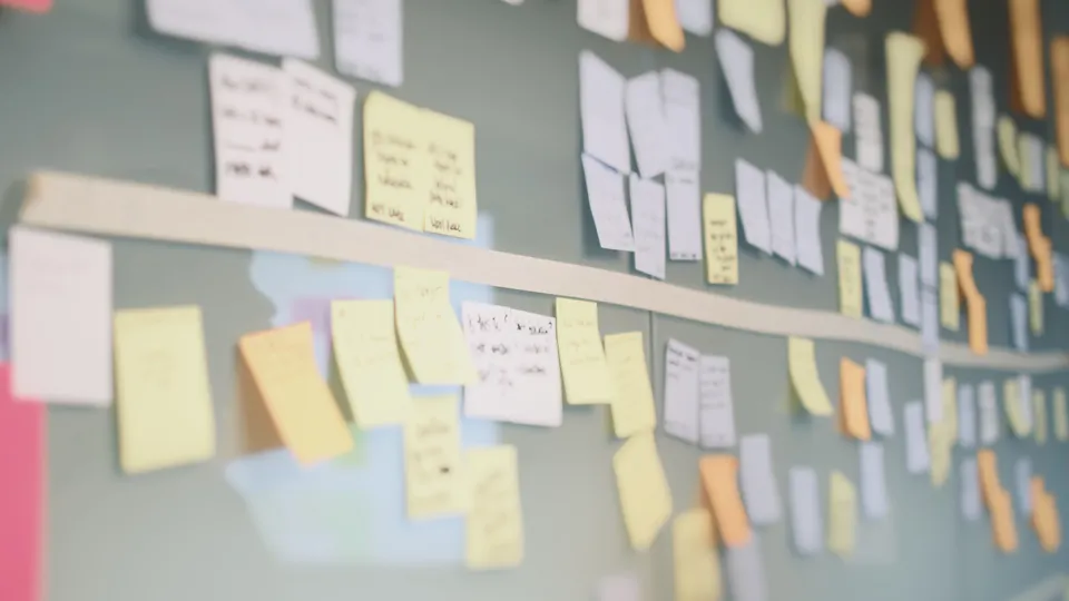 Illustrative photo: Glass wall covered with grouped sticky notes.