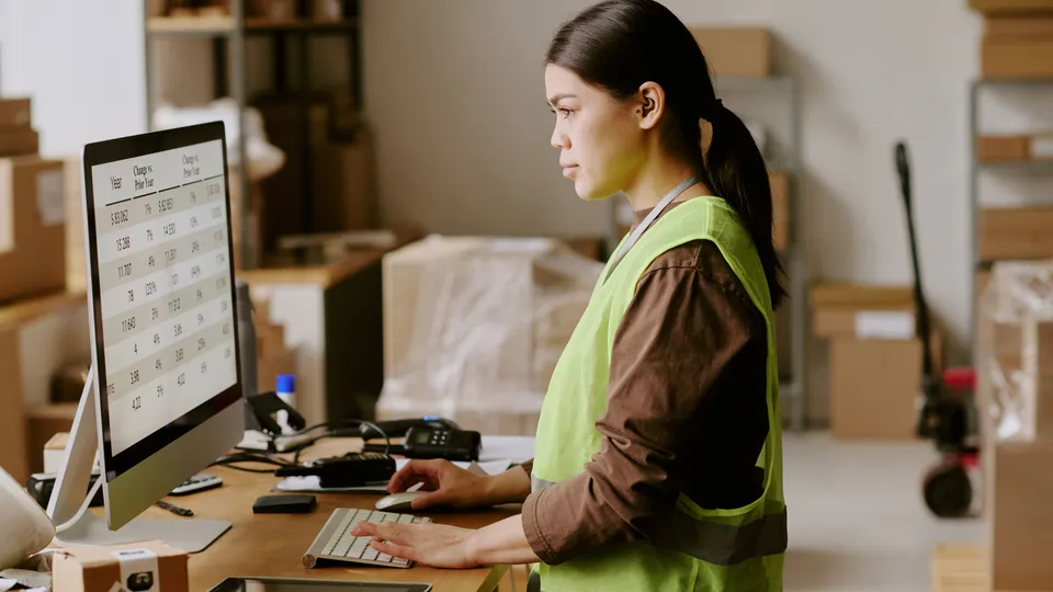 Illustrative photo: Warehouse employee working at a desktop computer.